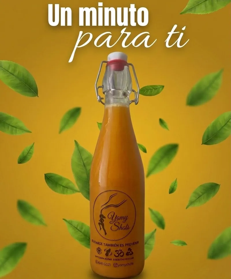 Botella de shot de jengibre con tapa metálica sobre fondo amarillo con hojas verdes